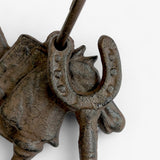 Side view of decorative horse head charm with weathered cast iron finish and textured surface