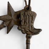 Close-up of cast iron horse charm and star ornament showing hand-cast texture and rust patina