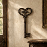 Oversized cast iron skeleton key wall decor hanging on a textured plaster wall