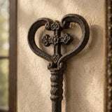Close-up of heart-shaped bow and cross detail on oversized cast iron skeleton key wall decor