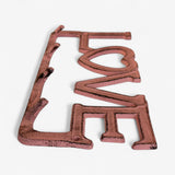 Cottage-style cast iron LOVE rack with heart opening and weathered reddish-brown vintage look