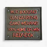 Redneck Pride cast iron plaque closeup, orange raised text, green-gray finish, humorous sign