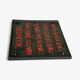 Redneck Pride sign angled view, cast iron with orange letters on textured metal