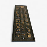 Cast iron late to work sign showing angled view with gold lettering on dark patina