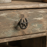 Black cast iron horseshoe and star drawer pull on a distressed wood cabinet