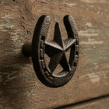 Close-up of black cast iron horseshoe star drawer pull on rustic wood