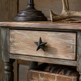 Black cast iron star drawer knob on a distressed rustic wood cabinet