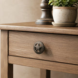 Black cast iron wagon wheel star cabinet knob on a wood drawer