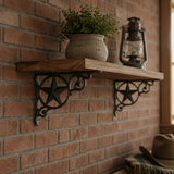 Black cast iron western star shelf brackets supporting a wood shelf on a brick wall