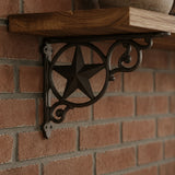 Close-up of black cast iron star shelf bracket with scrollwork under a wood shelf