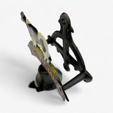Cast iron cow welcome sign side view with black painted cow, leather strap, and decorative bell