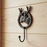 Cast iron deer head wall hook with antlers mounted on wood, rustic woodland home decor