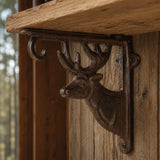 Brown cast iron deer head shelf bracket supporting a rustic wood shelf