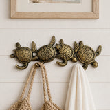Sea turtle cast iron hook rack mounted on white shiplap.