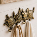 Close-up of cast iron sea turtle hook rack on wall.