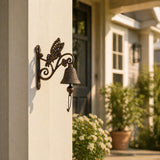 Cast iron butterfly doorbell hanging beside a house entryway.