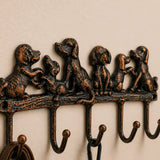 Close view of cast iron dog family hook rack with five hooks.