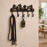 Cast iron dog family hook rack mounted on a wall with leashes.