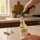 Hand holding green cast iron alligator bottle opener over a bottle.