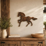 Cast iron running horse wall plaque mounted on a beige wall.