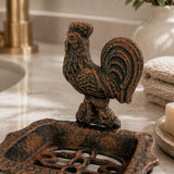 Close side view of cast iron rooster soap dish on marble.