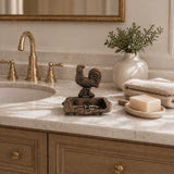 Cast iron rooster soap dish displayed on a bathroom vanity.