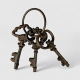 Three rustic bronze cast iron decorative key ornaments with aged patina and ornamental detail