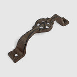 Ornate cast iron star handle on vintage blue-green barn door, farmhouse hardware accent