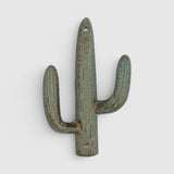 Close-up green patina cast iron saguaro cactus hook showing rust oxidation surface detail