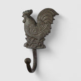 Gray cast iron rooster hook detail showing feathered wings and distressed rustic finish