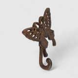 Ornate cast iron butterfly hook with oxidized patina showing three-dimensional sculptural wings and curved hook detail