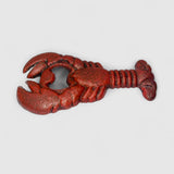 Dark verdigris cast iron lobster-shaped bottle opener with weathered patina on white