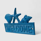 Blue cast iron beach welcome sign detail view showing textured finish and marine motifs