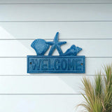 Blue cast iron coastal welcome sign with shell, starfish, seahorse toppers on white shiplap