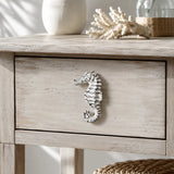 Distressed white seahorse cabinet knob on a light coastal wood drawer