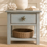 Coastal nightstand with brass starfish drawer knob, basket, coral, and books