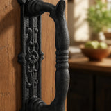 Close-up of textured black cast iron door pull handle with decorative backplate