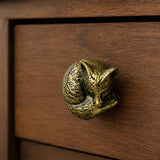 Antique brass fox cabinet knob on a warm wood drawer front