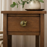 Wood nightstand with antique brass fox cabinet knob and vase decor