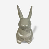 Cast iron bunny figurine with upright ears viewed from back cream colored with polished surface details
