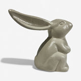 Cast iron bunny figure from side angle cream finish with glossy highlights and curved body design