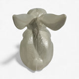 Cast iron bunny garden statue with shiny cream finish from back perspective with detailed sculptural work