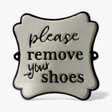 White cast iron wall plaque please remove your shoes black text, curved ornate shape