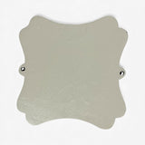 Cream colored cast iron decorative plaque with scalloped edges, mounting holes