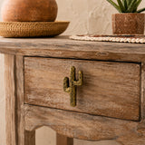 Antique brass cactus cabinet knob on a rustic wood drawer front