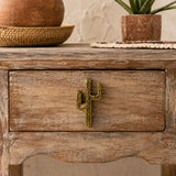 Close-up of cactus shaped drawer pull on a weathered wooden cabinet drawer