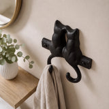 Angled view of black cast iron kissing cats wall hook with visible screws, SKU GB78064