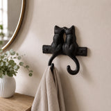 Black cast iron kissing cats double wall hook holding a towel in a bathroom, SKU GB78064