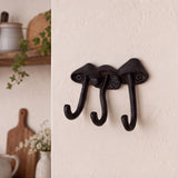 Dark brown cast iron mushroom 3-hook wall rack mounted in a kitchen entry space, SKU GB78067