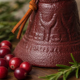 Close-up of raised pattern detail on burgundy cast iron dinner bell, SKU GB78097